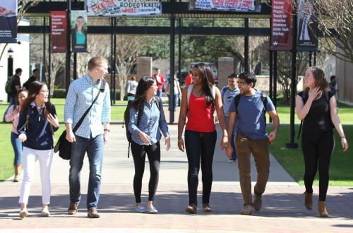 Diverse group of undergraduate students walking on campus at University of St. Thomas in Houston, Texas