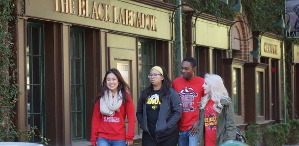 University of St. Thomas students walking past the Black Labrador restaurant and British pub in the Montrose neighborhood of Houston, Texas