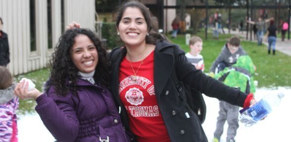 Two undergraduate students, with one holding a snowball during the Deck the Mall holiday celebration at the University of St. Thomas in Houston, Texas