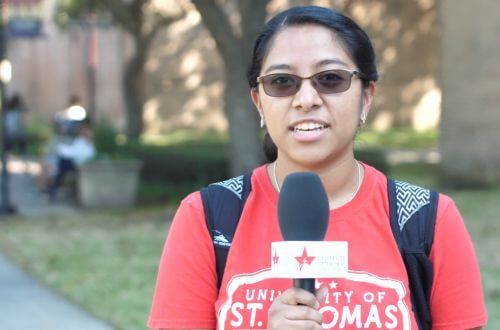 Undergraduate student speaking into microphone on the campus of the University of St. Thomas in Houston, Texas