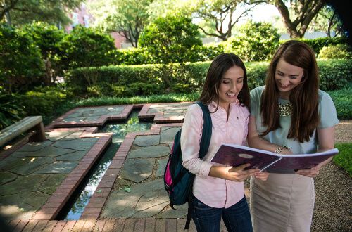 Two female students review notes on the University of St. Thomas - Houston campus
