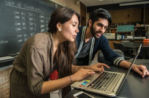 Two students work on a laptop at the University of St. Thomas - Houston