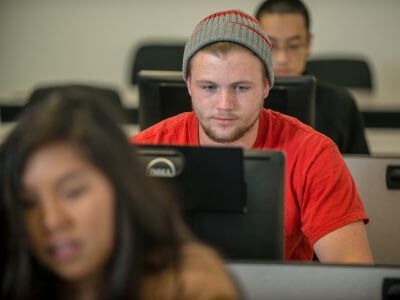 Students taking exam on computer in classroom