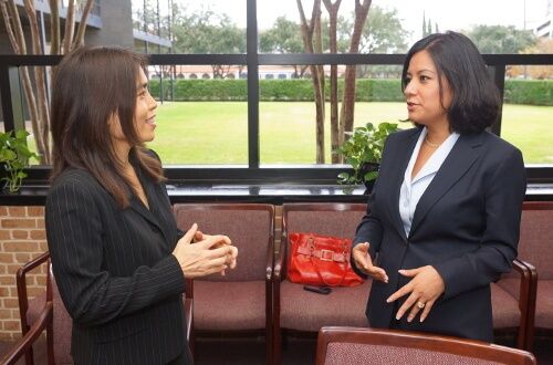 Two University of St. Thomas - Houston business majors talk in conference room