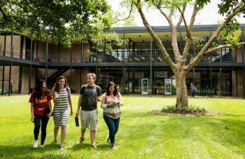 Four University of St. Thomas - Houston Math Club students walk across campus