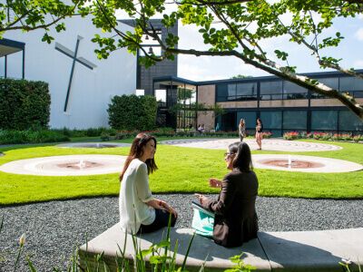 Two University of St. Thomas - Houston Political Science students sit outside the Chapel of St. Basil