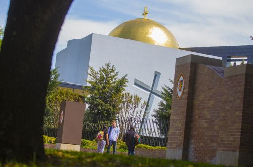 MBA students on campus in front of the Chapel of St. Basil at University of St. Thomas - Houston