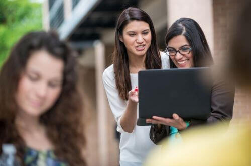 University of St. Thomas - Houston MSF Master of Science in Finance students on campus look at laptop