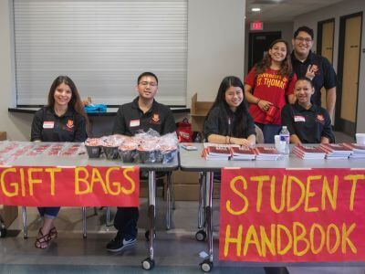 Students at welcome table during move-in day at Guinan Hall dorm on the campus of the University of St. Thomas in Houston, Texas