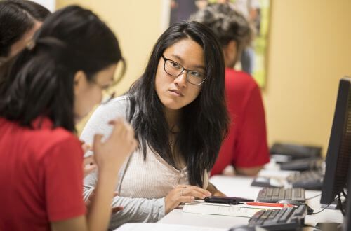 Asian student in front of computer at University of St. Thomas in Houston, Texas