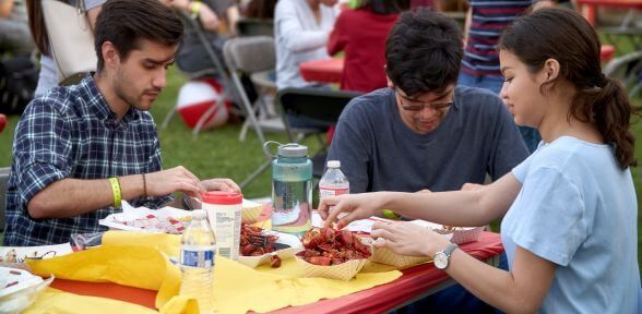 Three students during annual Crawfish Boil at University of St. Thomas in Houston, Texas