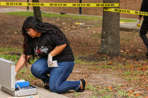 UST police officer speaks to University of St. Thomas - Houston Criminology majors in front of police car