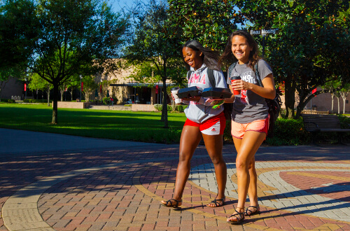 University of St. Thomas - Houston two female undergraduate students walk on campus