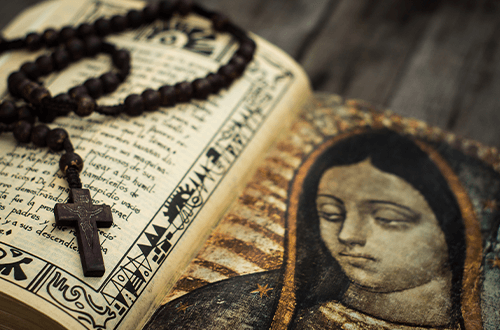 Rosary on top of a sacred text 